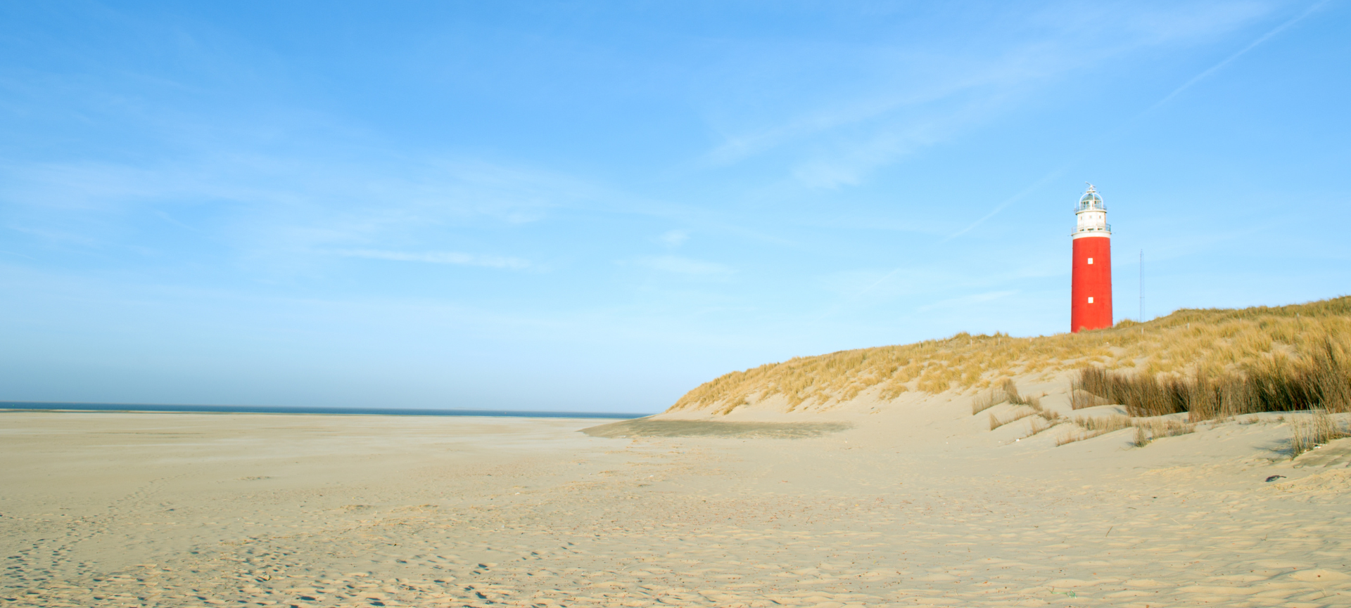 De beroemde vuurtoren van Texel bij helder weer, een populaire bezienswaardigheid voor op vakantie.